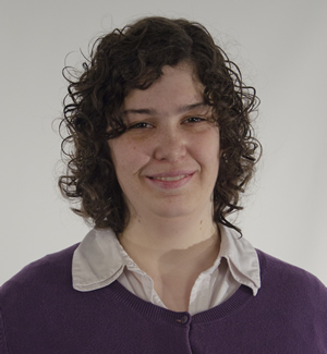 A portrait-style headshot of Miranda against a gray background